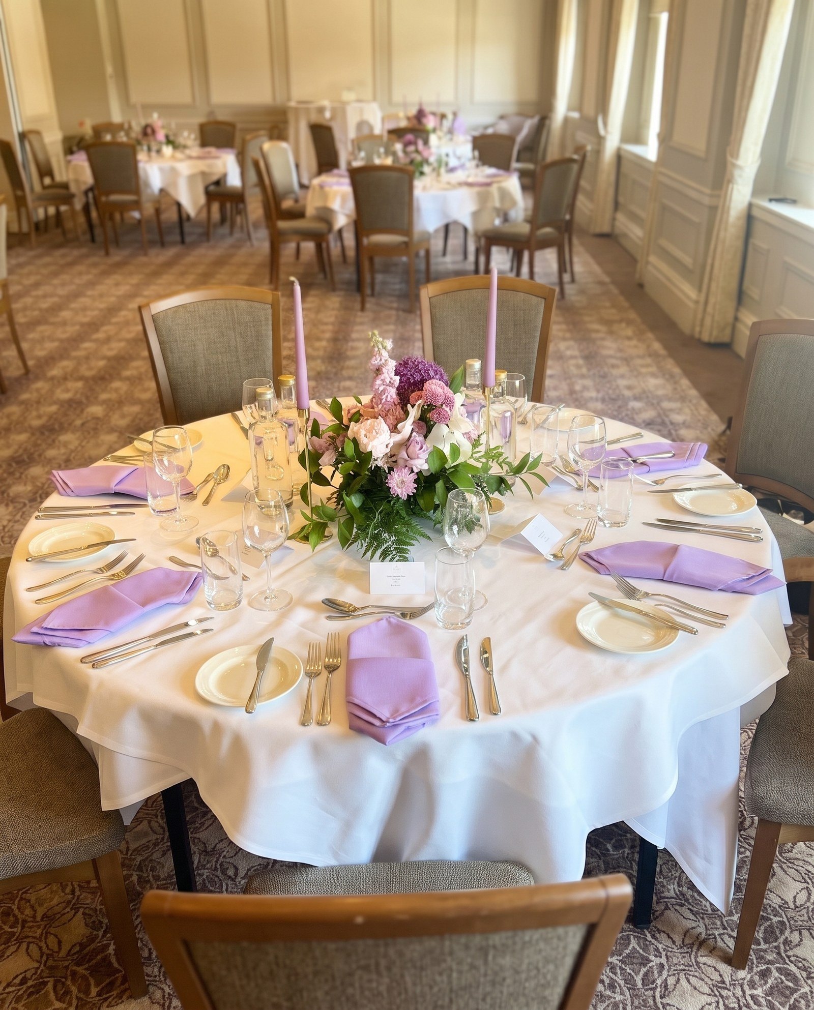 Low lilac and white garden-style centrepiece with lilac taper candles